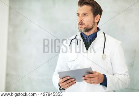 Photo Of A Doctor Looking Straight Ahead With A Planchette In His Hands