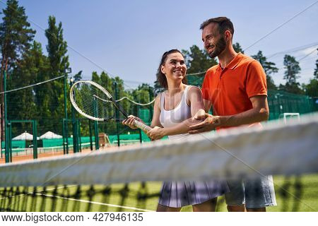 Woman Learning A Proper Serve Stance During The Tennis Session