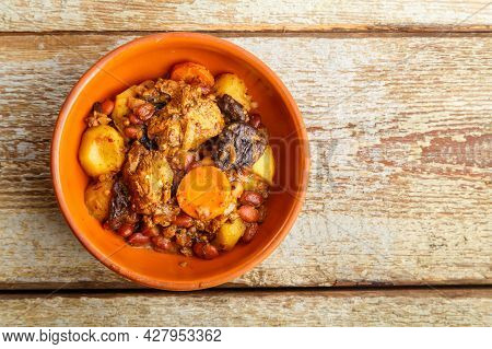 Jewish Dish Chelnt With Meat On A Wooden Table In A Plate. Copy Space Horizontal Photo