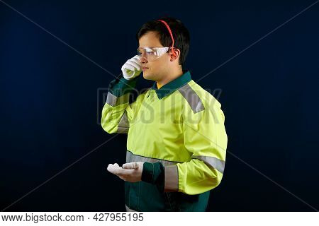 A Working Man Puts On Earplugs. Hearing And Vision Protection Equipment. A Worker Wearing Protective