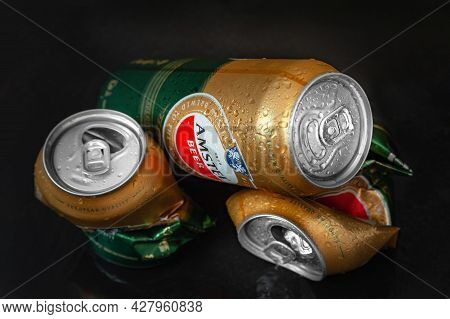 Beer Cans. Wet Crumpled And Full Beer Cans Amstels Drops On Dark Background, Close-up. Amstel World 