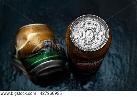 Beer Cans. Wet Crumpled And Full Amstel Beer Cans With Condensation Drops On A Dark Background, Top 
