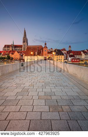 Regensburg, Germany. Cityscape Image Of Regensburg, Germany With Old Stone Bridge Over Danube River 