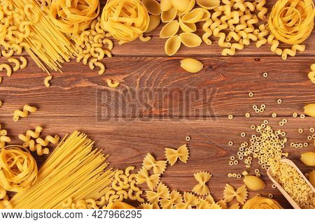 Different Types Of Raw Pasta Close-up On A Colored Background.