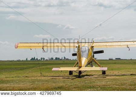 Yellow Vintage Plane On The Airfield Waiting To Go Into The Air View From The Back. Conventionally L