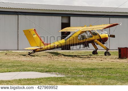 Yellow Vintage Plane On The Airfield View From The Side Near Hangar. Aircraft For Active Extreme Spo
