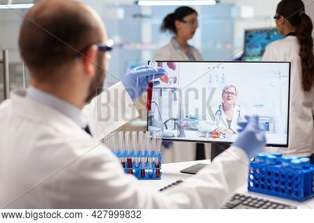 Medical Expert Having A Conversation About Virus Treatment Showing Sample Of Blood During Online Vid