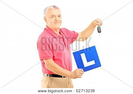 Smiling senior man holding a L plate and car key isolated on white background
