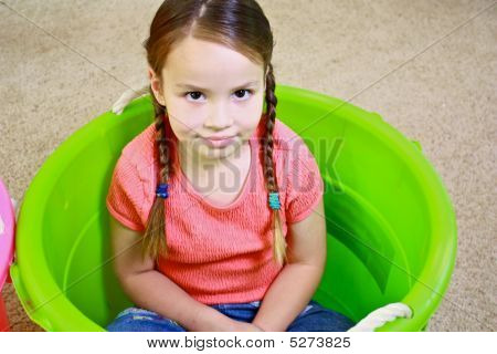 緑のバケツで遊ぶ若いかわいい女の子