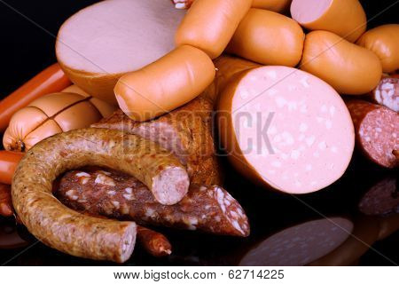 Lot of different sausages on black background
