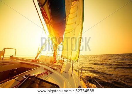 Sail boat in an open sea at sunset