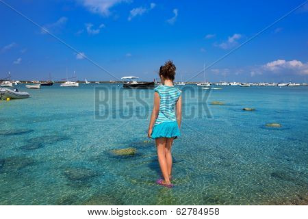 Kid girl walking at formentera in Estany des Peix lake rear view