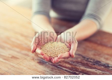 cooking and home concept - cloes uo of female cupped hands with quinoa