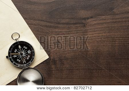 compass and old paper on the brown wooden table
