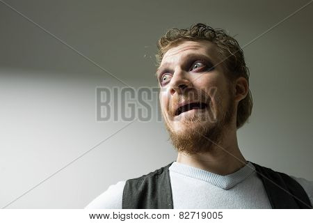 frightened man with red painted eyes.