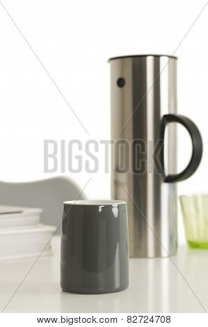 Gray Coffee Cup Beside Silver Vacuum Flask