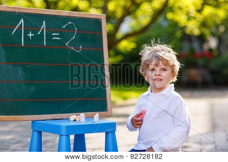 Little Boy At Blackboard Practicing Mathematics