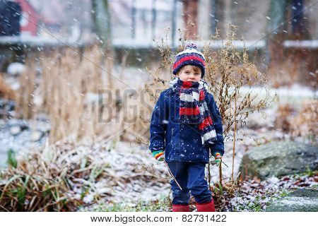 Cute Little Funny Boy In Colorful Winter Clothes Having Fun With Snow, Outdoors