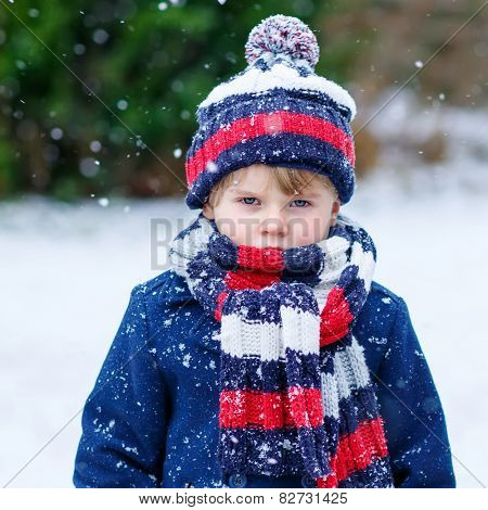 Sad Kid Boy In Colorful Winter Clothes Having Fun With Snow, Outdoors