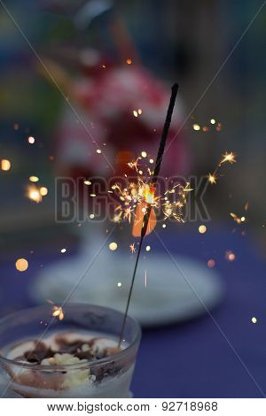 Festive Sparkels In An Ice Cream Cup On A Table With A Purple Table Cloth