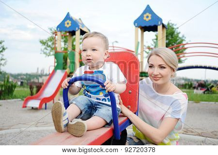 Mom And Baby Son Play In The Playground