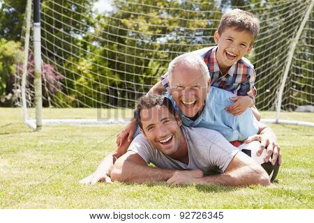 Grandfather, Grandson And Father With Football In Garden