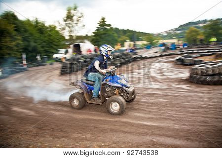 Young Boy Is Faszinated By Quad Driving And Enjoyes Is, His Face Is Dirty From Mud