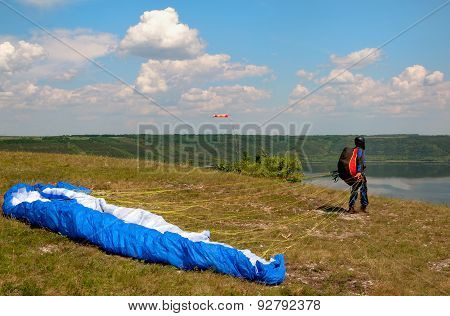 Paraglider Prepares To Fly Over Beautiful Bakota Reservoir.