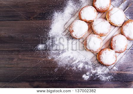German donuts - berliner with icing sugar on a dark wooden background. Top view with copy space