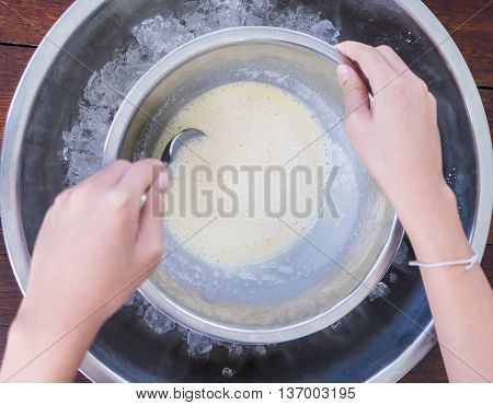 Children making home made ice cream with iced bowl. Spinning steel bowl for making Vanilla Ice Cream.