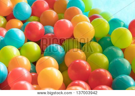 Multi colored highly saturated plastic balls in soft-play ball-pit at a child's play-park