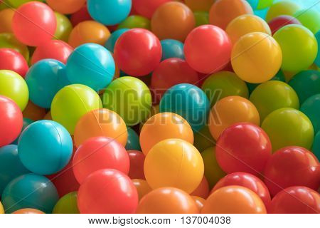 Multi colored highly saturated plastic balls in soft-play ball-pit at a child's play-park