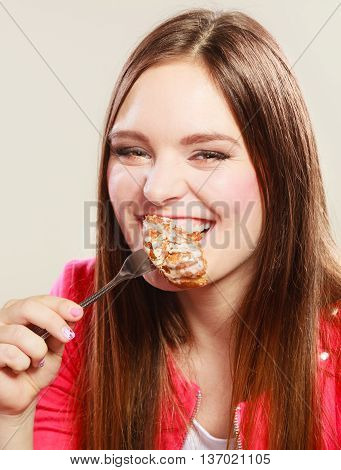 Smiling woman eating cake. Caloric healthy food.
