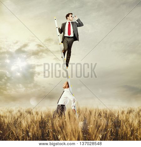 Man holds up the ladder to a man with binoculars