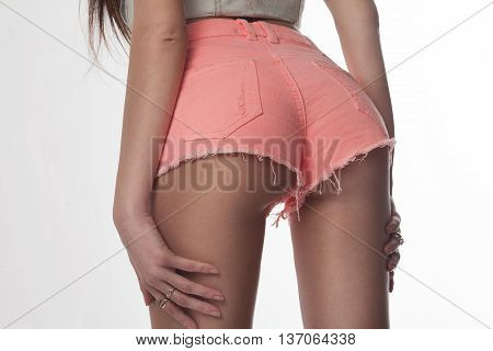 Sexy woman body in jeans shorts. The model is back. Great ass. Studio shot on white background.