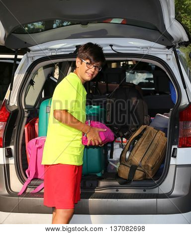 Boy With Glasses Loaded The Luggage In The Trunk Of The Car