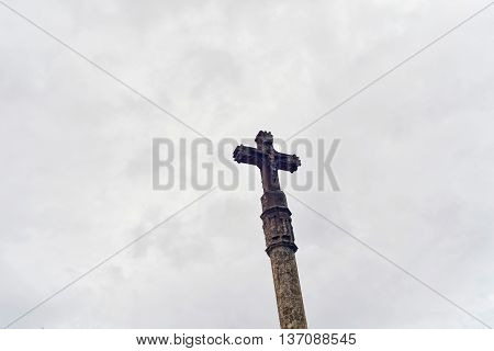 Stone Cross Against Cloudy Sky At The Sanctuary Of Cura. Mallorca. Spain.
