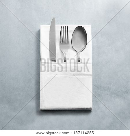 Blank white restaurant napkin mock up with knife fork and spoon, isolated. Cutlery in clear textile towel mock up template. Cafe branding identity clean napkin surface for logo design.