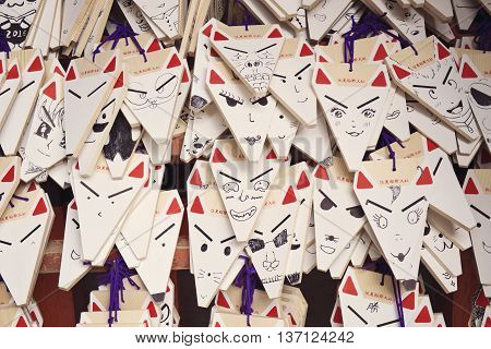 KYOTO, JAPAN - APRIL 29, 2016 : Ema prayer tablets with unique fox-shaped boards at Fushimi Inari Taisha Temple in Kyoto. Pray for luck, wealth, happiness, health, fortune, protection.