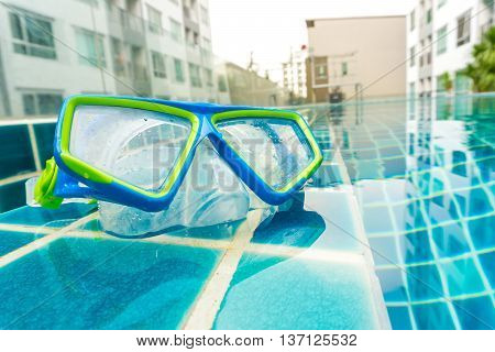 Snorkeling Mask On Swimming Pool Backgeound With Condominium