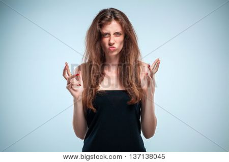 The and frowning young woman with long red hair on a gray background