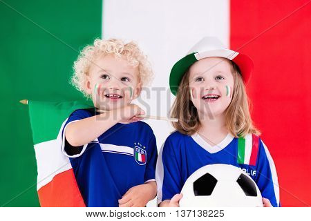 Children cheering and supporting Italian national football team. Kids fans and supporters of Italy during soccer championship.