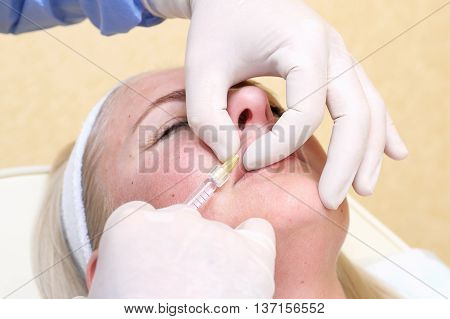 Procedure of lip injection with filler in clinic