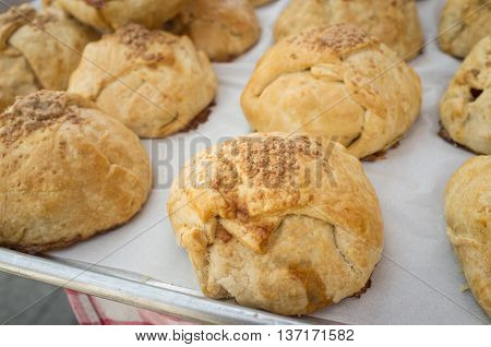 Closeup pile of fresh Irish cinnamon scones on wax paper