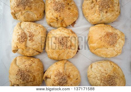 Closeup pile of fresh Irish cinnamon scones on wax paper