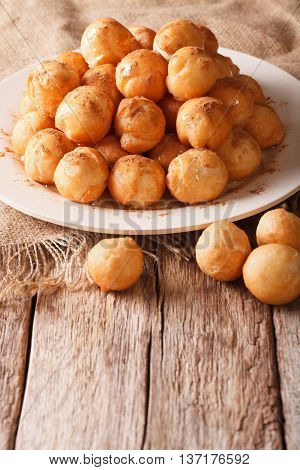 Mediterranean Cuisine: Fried Donuts With Honey And Cinnamon Close-up. Vertical