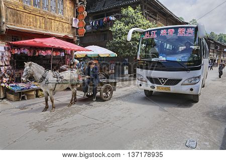 Zhaoxing Dong Village Guizhou Province China - April 8 2010: Chinese Public transport in the countryside of ethnic minorities shuttlebus and horse drawn vehicle.