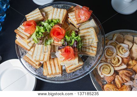 Cheese sandwiches and egg salad, arranged on a platter and garnished with salad.