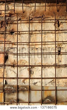 Rusty skeleton lattice of iron rods on a brick wall