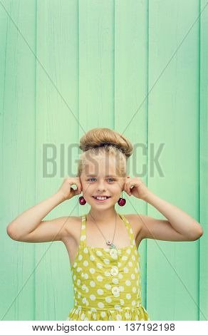 Beautiful girl holding cherries as earrings -style Rockabilly. Space for text